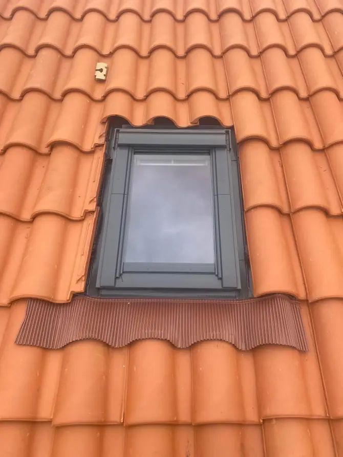 Fenêtre de toit posée dans une couverture en tuiles neuves