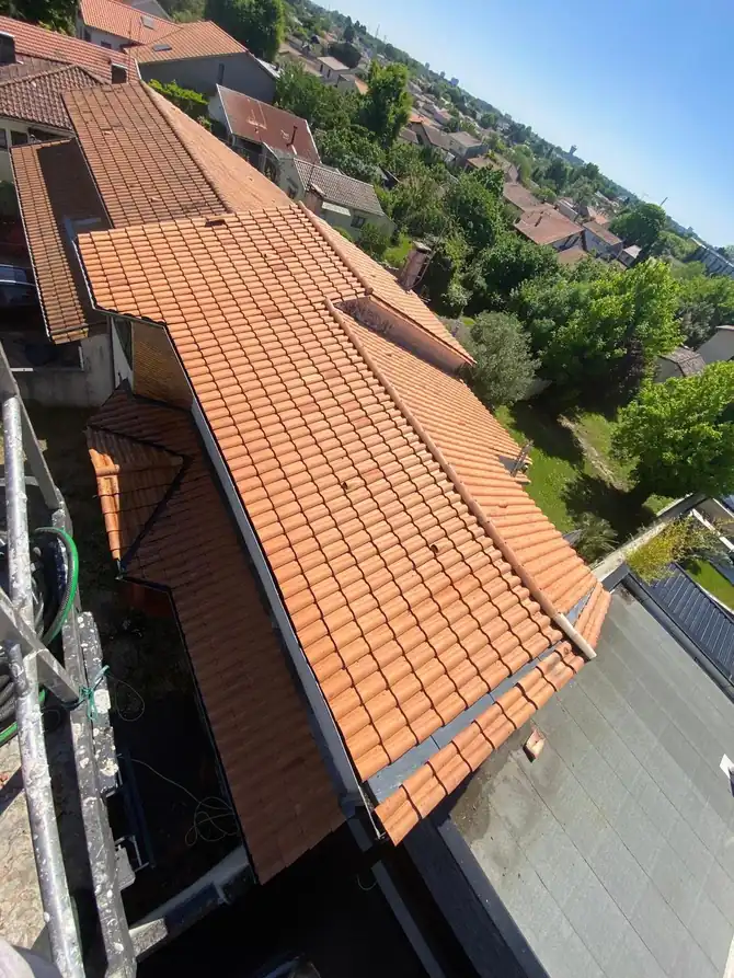Toiture neuve en tuiles orange vue depuis le faîtage