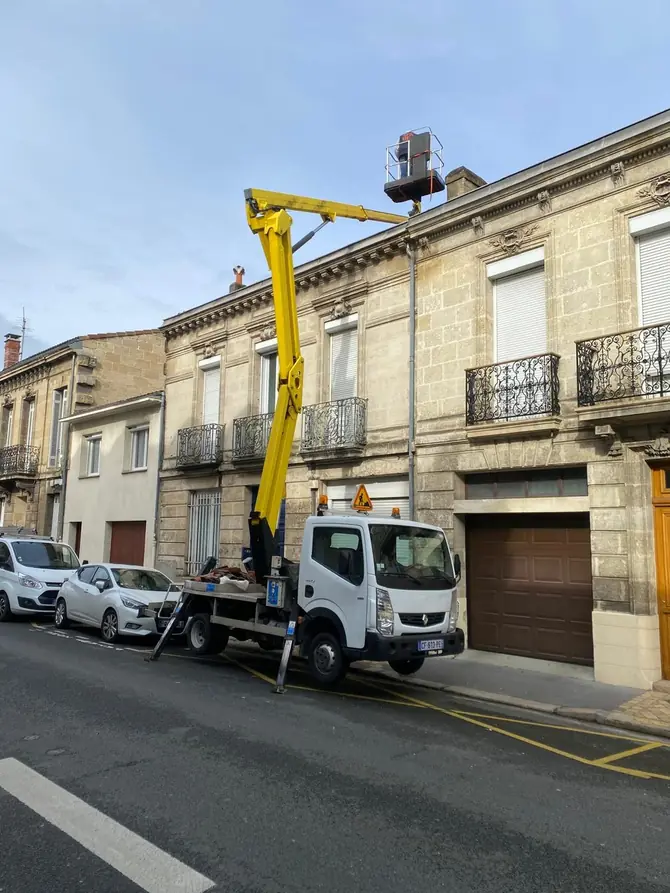 Nacelle élévatrice stationnée devant une maison de ville