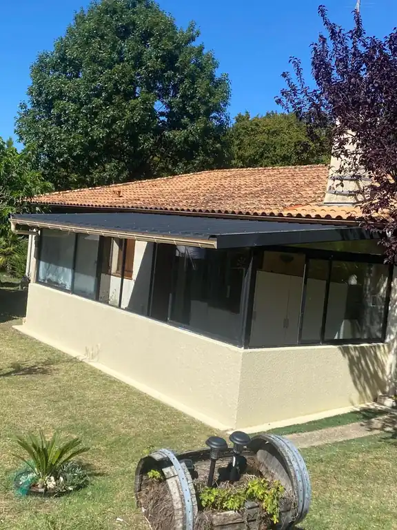 Maison et sa véranda, souche de cheminée en pierre