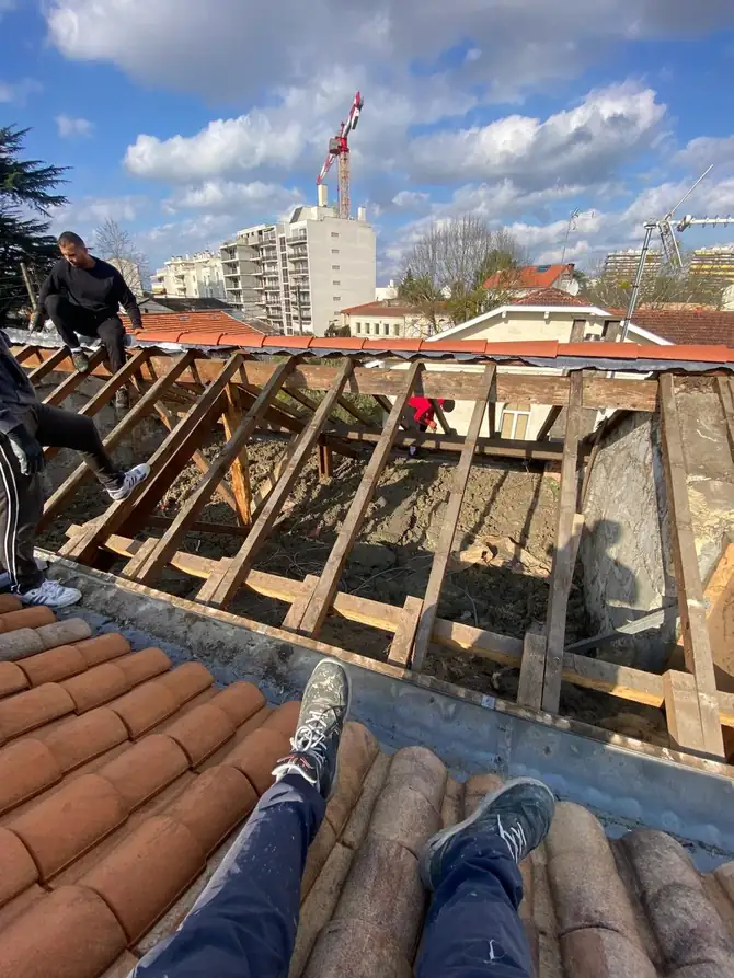 Charpente mise à nu pendant une dépose, ville en arrière-plan